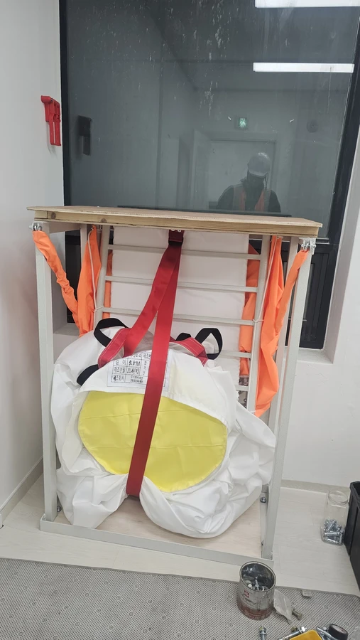 수직구조대 설치절차 현장 사진 — 창가 개구부에 고정된 수직구조대 프레임과 수납부