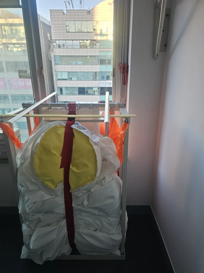 수직구조대 견적 — 창가 개구부에 고정된 수직구조대 프레임과 수납부