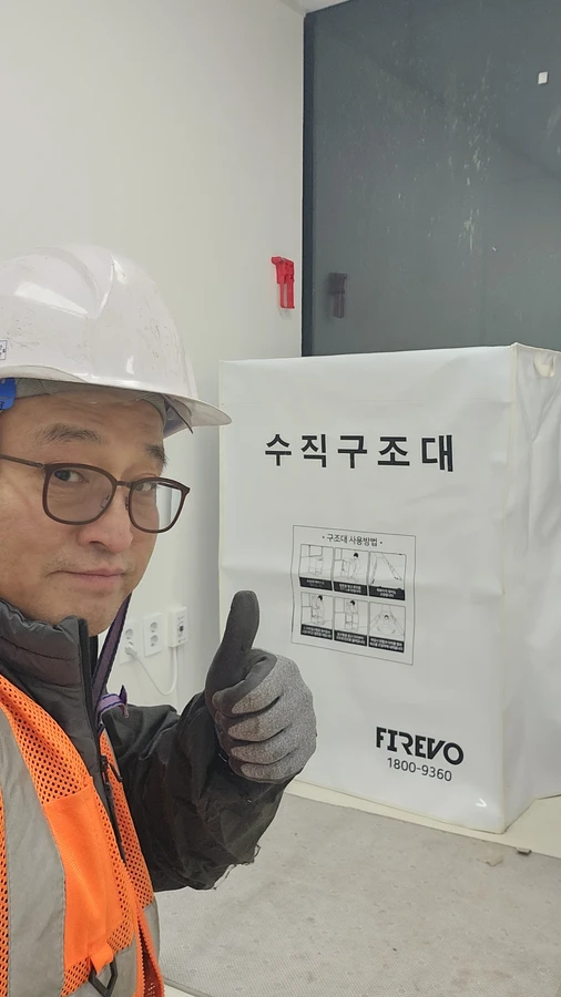 수직구조대 설치계획 현장 사진 — 안전모를 쓴 담당자와 수직구조대 수납함