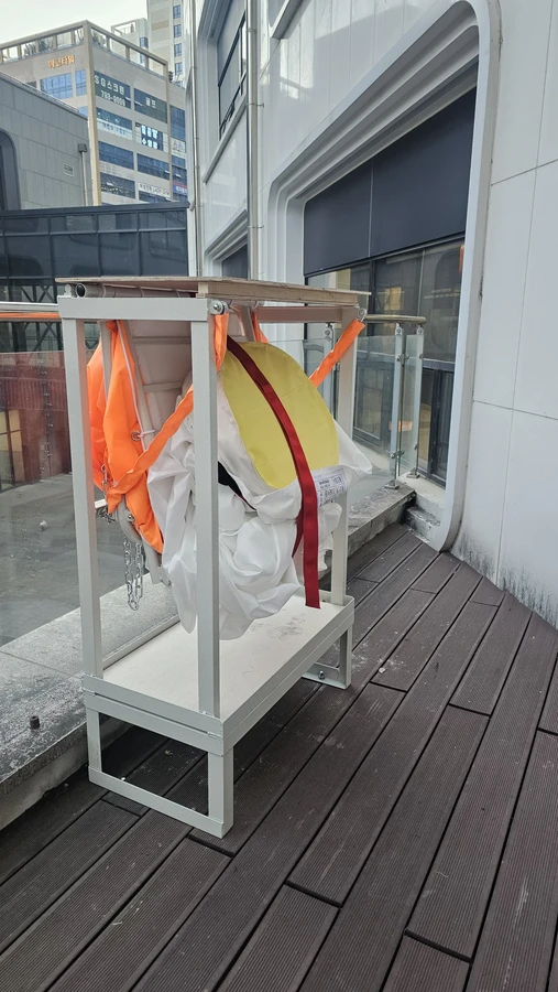 수직구조대 설치설계 현장 사진 — 창가 개구부에 고정된 수직구조대 프레임과 수납부
