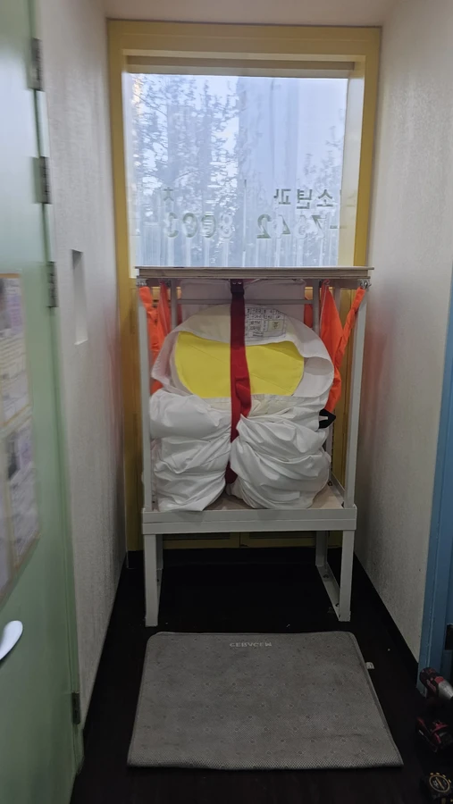 수직구조대 학교설치 — 창가 개구부에 고정된 수직구조대 프레임과 수납부