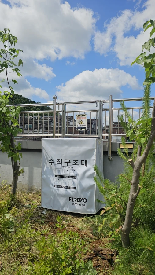 수직구조대 설치방법 — 옥외 난간 아래 설치된 수직구조대 수납함