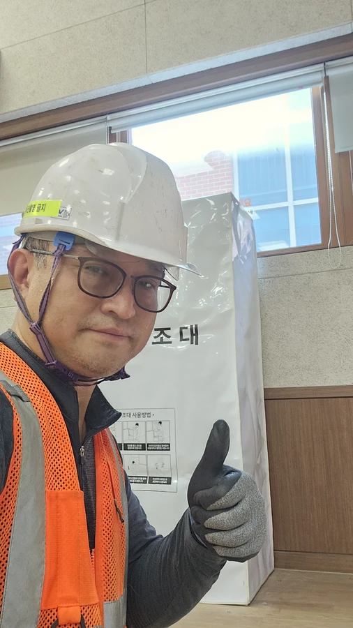 수직구조대 시공사례 현장 사진 — 현장 담당자와 수납함이 설치된 실내