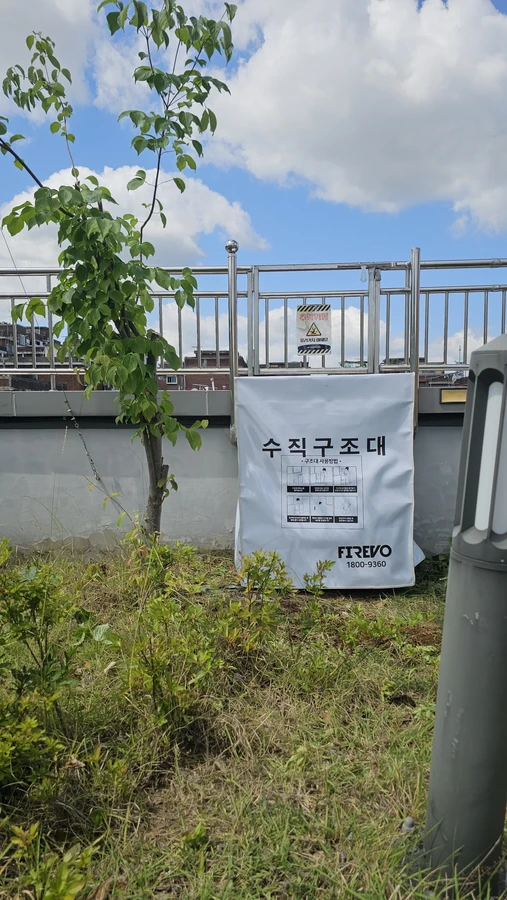 수직구조대 설치높이 현장 사진 — 옥외 난간 아래 설치된 수직구조대 수납함