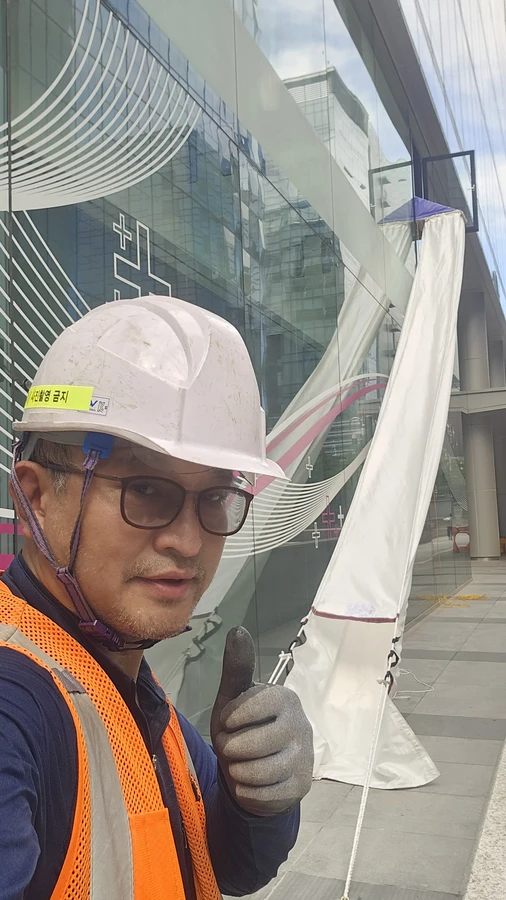 수직구조대 성능관리 — 안전모를 쓴 담당자와 펼쳐진 하강 통로